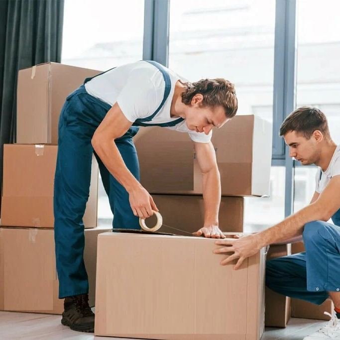 Movers wrapping a sofa in protective blankets in Dubai