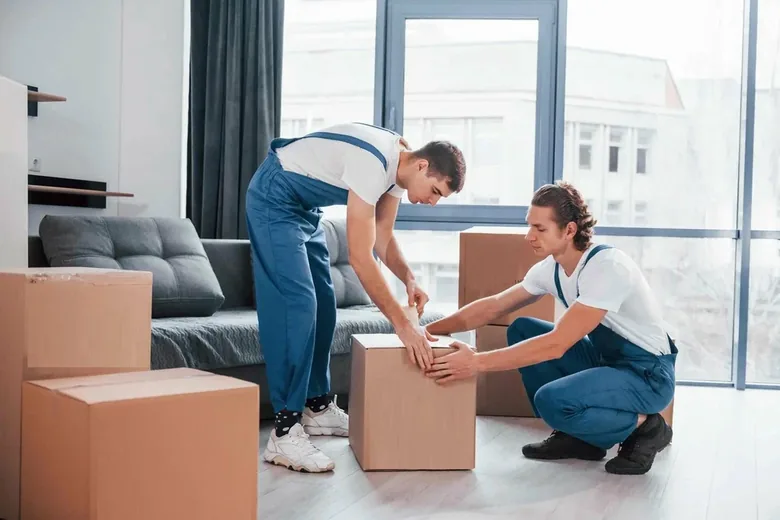 Moving crew professionally packing household items in a Dubai apartment
